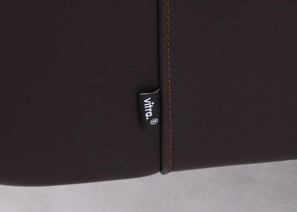 Detailaufnahme des Vitra Labels am Park Swivel Sessel mit braunem Leder